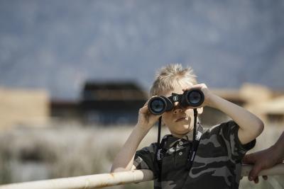 Boy looking through binoculars at Bear River Migratory Bird Refuge